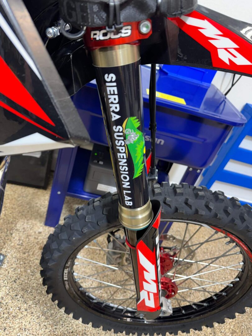 Close-up of a dirt bike front fork with Sierra Suspension branding.